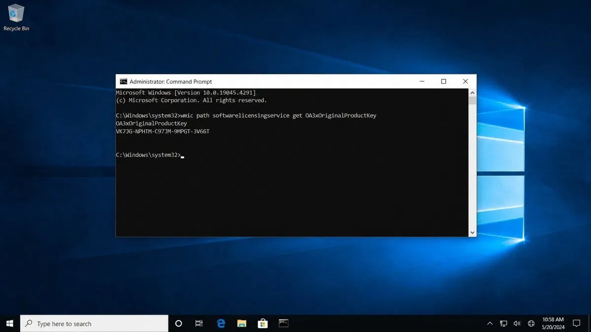Windows desktop with an elevated Command Prompt window open displaying the output of a command that reports the machine Windows product key